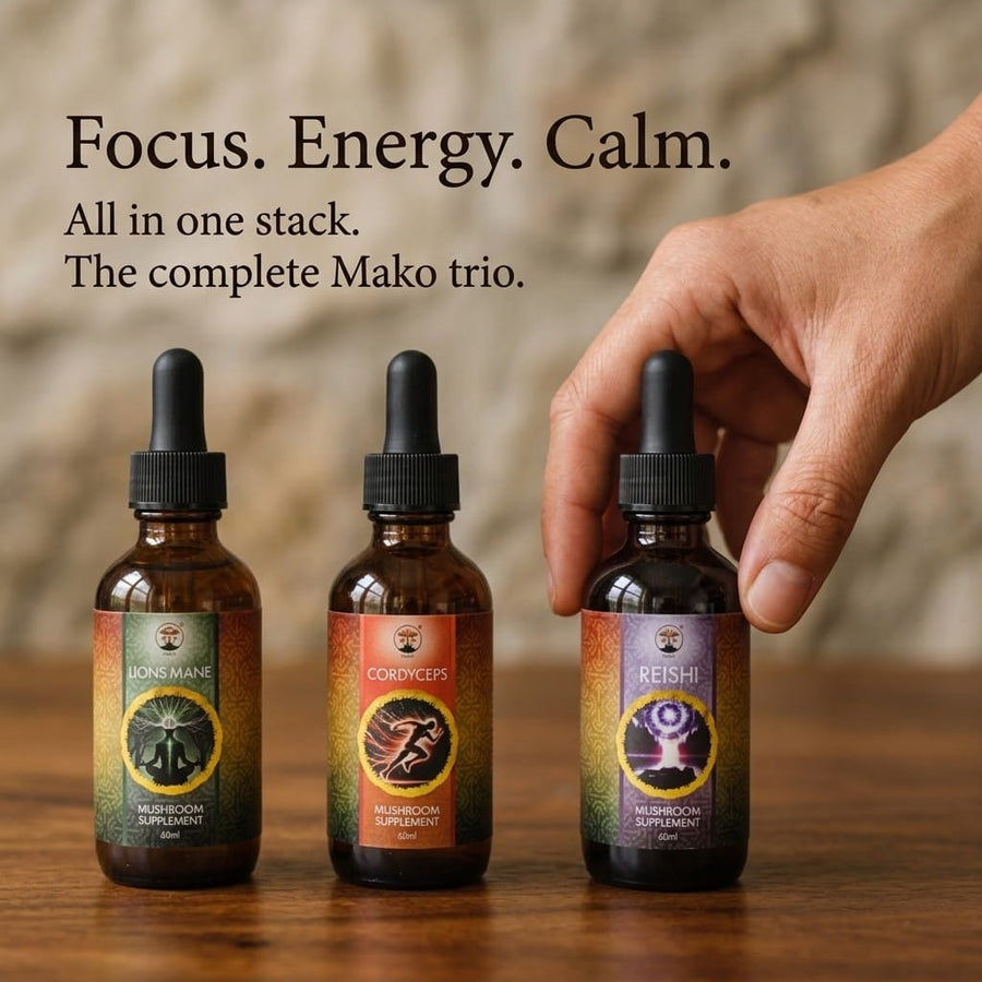 Three Mako mushroom supplement bottles on a wooden surface with a hand reaching for one of them. Lions mane, Cordyceps and Reishi